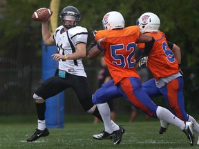 Windsor AKO Fratmen quarterback Austin Lumley, left, scrambles from the St. Leonard defence at Windsor Stadium, Saturday, August 31, 2013. (DAX MELMER/The Windsor Star)