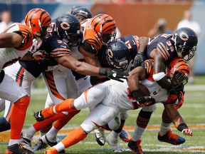Cincinnati Bengals running back BenJarvus Green-Ellis (42) is tackled by Chicago Bears cornerback Charles Tillman (33), safety Major Wright (21) and defensive end Corey Wootton (98) during the first half of an NFL football game, Sunday, Sept. 8, 2013, in Chicago. (AP Photo/Charles Rex Arbogast)