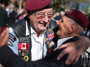Ralph Mayville, of the First Special Service Force, also known as the Devil's Brigade, gets a hug from Peter Hunter, left, of the 15th Scottish Airborne, at the 67th Annual Reunion of the First Special Service Force Association at City Hall Square, Saturday, Sept. 28, 2013.  (DAX MELMER/The Windsor Star)