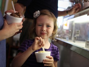 Irelyn Peacock, 5, digs into a bowl of vanilla ice cream with her half-brother, Colin Burke, 9, left, while at Sunset Ice Cream and Gifts, Saturday, Sept. 7, 2013.  Sunset Ice Cream and Gifts was holding a fundraiser for the family of One-year-old Emma Pizzuti, who was diagnosed with a rare form of cancer in March.  (DAX MELMER/The Windsor Star)