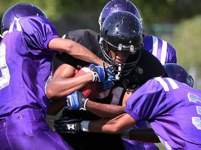 Riverside running back Emeka Omenugha, centre, is swarmed by Assumption's Desmond Verro, left, and Mony Keo in high school football action from Windsor Stadium Thursday Sept. 12, 2013. (NICK BRANCACCIO/The Windsor Star)