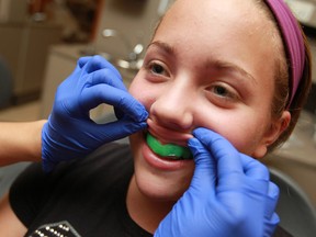 Taylor Quenneville, 14, tries out her new mouthguard at a free custom mouthguard clinic at St. Clair College, Saturday, Sept. 14, 2013.  (DAX MELMER/The Windsor Star)