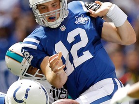 Indianapolis Colts' Andrew Luck (12) fumbles the ball as he is sacked by Miami Dolphins' Derrick Shelby during the first half an NFL football game on Sunday, Sept. 15, 2013, in Indianapolis. The Colts recovered the ball. (AP Photo/Michael Conroy)