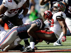 New England Patriots middle linebacker Brandon Spikes (55) tackles Tampa Bay Buccaneers running back Doug Martin (22) in the first half of an NFL football game Sunday, Sept. 22, 2013, in Foxborough, Mass. (AP Photo/Elise Amendola)