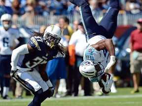 Tennessee Titans wide receiver Kenny Britt (18) flips upside down after making a catch as he is defended by San Diego Chargers defensive back Jahleel Addae (37) in the second quarter of an NFL football game on Sunday, Sept. 22, 2013, in Nashville, Tenn. The pass was incomplete, Britt was unable to hold onto the ball. (AP Photo/Mark Zaleski)