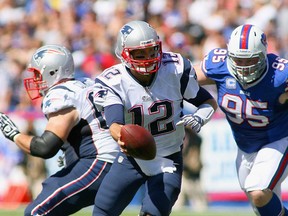 Tom Brady #12 of the New England Patriots readies to hand off with pressure from  Kyle Williams #95 of the Buffalo Bills at Ralph Wilson Stadium on September 8, 2013 in Orchard Park, New York.  (Photo by Rick Stewart/Getty Images)