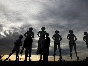 Children play next to silhouettes of Terry Fox before the starts of LaSalle's Terry Fox Run, Sunday, Sept. 15, 2013.  (DAX MELMER/The Windsor Star)