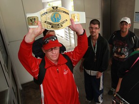 Edward O'Brien holds up a replica of the Intercontinental Heavyweight Wrestling Championship belt as a group of fans wait outside the Windsor Star News Cafe to see WWE star Dolph Ziggler, Saturday, Sept. 7, 2013. (DAX MELMER/The Windsor Star)