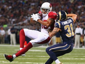 Arizona's Michael Floyd, left, catches a 44-yard pass against Cortland Finnegan of the Rams at the Edward Jones Dome Sunday. (Photo by Dilip Vishwanat/Getty Images)
