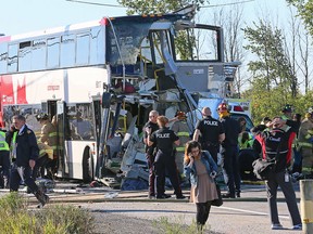 The front of the bus is barely distinguishable while firefighters and police search at the scene of a horrific crash between an OC Transpo double decker bus and a VIA train near the Fallowfield station in Barrhaven, a suburb community in South West Ottawa. (Wayne Cuddington / Ottawa Citizen)
