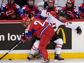 Team Russia's Angelina Goncharenko, left, collides with Team Canada's Meghan Agosta-Marciano at the IIHF Womens World Ice Hockey championships in Ottawa earlier this year. (THE CANADIAN PRESS/Adrian Wyld)