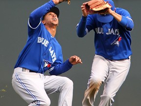 Toronto's Rajai Davis, left, makes a catch in front of teammate Ryan Goins against the Minnesota Twins. (Photo by Andy Clayton-King/Getty Images)