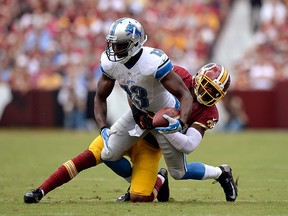 Nate Burleson #13 of the Detroit Lions is tackled by David Amerson #39 of the Washington Redskins after catching a pass from Matthew Stafford #9 (not pictured) in the first quarter during a game at FedExField on September 22, 2013 in Landover, Maryland.  (Photo by Patrick McDermott/Getty Images)