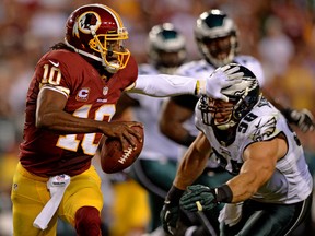 Redskins quarterback Robert Griffin, left, stiff arms Eagles linebacker Connor Barwin in the third quarter at FedExField in Landover, Maryland. (Photo by Patrick Smith/Getty Images)