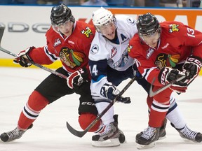 Portland's Joey Baker, left, and Keegan Iverson, right, check Saskatoon's Darren Dietz during the third period of Memorial Cup action in Saskatoon. (THE CANADIAN PRESS/Liam Richards)