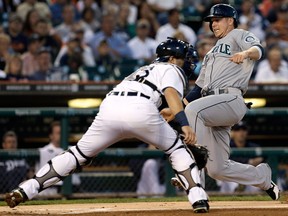 Seattle's Justin Smoak, right, scores past the tag of Detroit catcher Alex Avila on a Michael Saunders double in the second inning Wednesday in Detroit. (AP Photo/Paul Sancya)