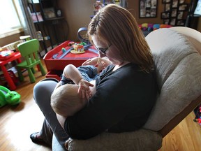 Ginger Girard Fram breastfeeds her 10-month-old son Robin, Monday, Sept. 30, 2013, at her Windsor, Ont. home. She is a midwife who helps new mothers with the breastfeeding process. (DAN JANISSE/The Windsor Star)
