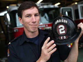 Windsor fire Capt. David Gillis, holds a donated antique Windsor fire helmet in front of Fire Station 4, Sunday, Sept. 29, 2013. (DAX MELMER/The Windsor Star)