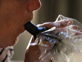 In this file photo, a medical marijuana user uses a vaporizer at their home in Windsor on Wednesday, September 4, 2013. ECGreen is planning to open up a marijuana production facility in Oldcastle to grow cannabis for licensed medical users. (Windsor Star files)