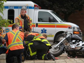 Emergency workers tend to a motorcyclist who crashed his motorcycle in the 3200 block of Sandwich St., Sunday, Sept. 8, 2013. Injuries are unknown as police investigate. (DAX MELMER/The Windsor Star)