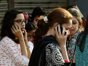 Pakistani office workers speak on their mobile phones on the street after an earthquake in Karachi on September 24, 2013. A powerful 7.8-magnitude earthquake hit southwestern Pakistan on, the U.S. Geological Survey said, with tremors felt as far as the Indian capital New Delhi. The area of the epicentre is sparsely populated, but the USGS issued a red alert for the quake, warning that heavy casualties were likely, based on past data. (RIZWAN TABASSUM/AFP/Getty Images)