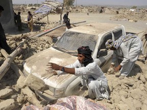 Pakistani survivors clear the debris of destroyed houses in the earthquake-devastated district of Awaran on September 25, 2013. Desperate villagers in southwest Pakistan clawed through the wreckage of their ruined homes, a day after a huge earthquake struck, killing more than 270 people and creating a new island off the coast.   (BANARAS KHAN/AFP/Getty Images)