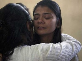Sonali Shah, right, fiance of 24-year-old Rajan Lalitkumar Solanki, is consoled during a prayer ceremony at Arya Samaj Temple in Nairobi, Kenya, Sunday, Sept. 29, 2013. Solanki was killed in the Westgate Mall attack. The masked gunmen who infiltrated Nairobi's Westgate mall arrived with a set of religious trivia questions: As terrified civilians hid, the assailants began a high-stakes game of 20 Questions to separate Muslims from those they consider infidels. (AP Photo/Sayyid Azim)