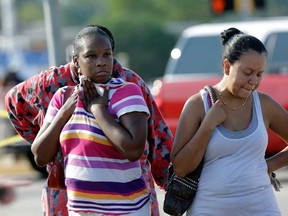 Parents, Eunice Pacheco, right, and LaKesia Brent wait for news about their children outside Spring High School Wednesday, Sept. 4, 2013, in Spring, Texas. A 17-year-old boy was airlifted from the school in suburban Houston with stab wounds suffered in an altercation at the campus. Spring is about 20 miles north of Houston. (AP Photo/David J. Phillip)