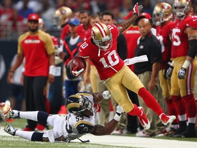 Kyle Williams #10 of the San Francisco 49ers is knocked out of bounds by Daren Bates #53 of the St. Louis Rams during a punt return at the Edward Jones Dome on September 26, 2013 in St. Louis, Missouri. The 49ers beat the rams 35-11. (Photo by Dilip Vishwanat/Getty Images)