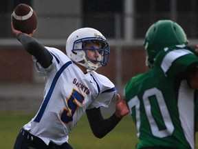 St. Anne quarterback Nick Caliwliw, left, throws a pass in front of Herman's T.J. Lantz during WECSSAA boys football action at Herman Friday. (DAX MELMER/The Windsor Star)