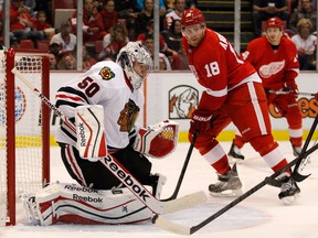 Chicago goalie Corey Crawford, left, makes a save in front of Detroit's Joakim Andersson during the second period of a pre-season game at Joe Louis Arena Sunday. (AP Photo/Duane Burleson)