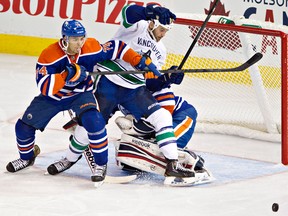 LaSalle's Zack Kassian, centre, battles in front of the net with Edmonton's Darnell Nurse Saturday in Vancouver. (THE CANADIAN PRESS/Jason Franson)