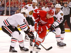 Detroit's Gustav Nyquist, centre, tries to split the Chicago defence of Niklas Hjalmarsson, right, and Duncan Keith at Joe Louis Arena. (Photo by Gregory Shamus/Getty Images)