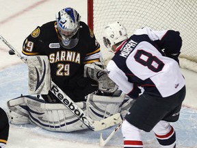 Spitfires defenceman Trevor Murphy, right, takes a shot on Sarnia goalie Taylor Dupuis at the WFCU Centre Thursday. (TYLER BROWNBRIDGE/The Windsor Star)