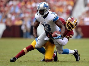 Detroit's Nate Burleson, front, is tackled by Washington's David Amerson at FedExField.  (Photo by Patrick McDermott/Getty Images)