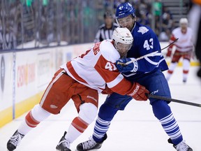 Toronto's Nazem Kadri, right, takes a penalty for holding Detroit's Luke Glendening Saturday, Sept. 28, 2013, in Toronto. (THE CANADIAN PRESS/Frank Gunn)