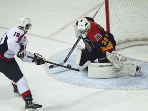 Spits forward Kerby Rychel, left, is stopped by Erie goaltender Oscar Dansk last year. Rychel scored three goals Saturday. (JASON KRYK/The Windsor Star)