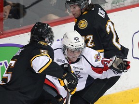 Spitfires rookie Ryan Moore, centre, tries to squeeze between Sarnia's Tyler Hore, left, and Jeff King at the WFCU Centre Friday. (TYLER BROWNBRIDGE/The Windsor Star)