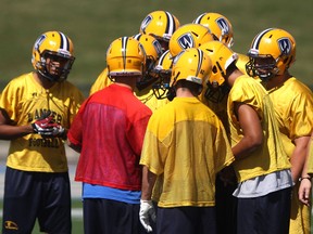 The University of Windsor football team huddles during practice at Alumni Field Friday, (DAX MELMER/The Windsor Star)