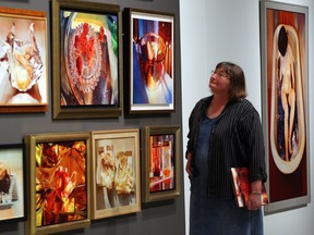 Mary Pratt curator Caroline Stone admires the warm tones of Pratt's exhibit at the Art Gallery of Windsor. (NICK BRANCACCIO / The Windsor Star)