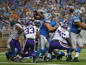 Joique Bell, centre, of the Detroit Lions scores on a two-yard run in the second quarter of the game against the Minnesota Vikings at Ford Field on September 8, 2013 in Detroit. (Leon Halip/Getty Images)