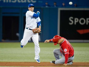 Blue Jays second baseman Ryan Goins, left, forces out Los Angeles' Hank Conger during the second inning in Toronto on Wednesday, Sept. 11, 2013. THE CANADIAN PRESS/Nathan Denette