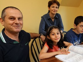 Students Melodi and Oguzhan Yilmaz (right) study with the help of their parents Ayse and Naci (left) Yilmaz at their home in WIndsor on Monday, September 16, 2013. Both Melodi and Oguzhan were in split grade classes at the start of the school year.           (TYLER BROWNBRIDGE/The Windsor Star)