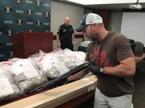 Constable Todd Pearce with the Windsor police drugs and guns unit displays a shotgun and drugs on Sept. 11, 2013, which were seized from a storage locker in Windsor.  (JASON KRYK/The Windsor Star)
