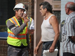 Peter Pereira, left, foreman supervisor for Coco Paving, gets into a verbal altercation with property owner, Mario Galati, where water main reconstruction is taking place on the 1300 block of Wyandotte St. East, Monday, September 23, 2013.  (DAX MELMER/The Windsor Star)