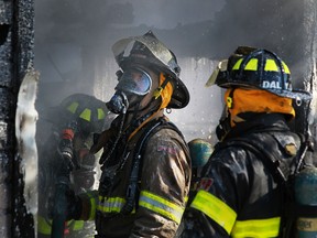 WINDSOR, ONT.: SEPT 14, 2013 -- Windsor firefighters tend to a garage fire at the corner of Windermere Road and Lens Avenue, Saturday, Sept. 14, 2013.  The fire started when the car parked in the garage malfunctioned.  (DAX MELMER/The Windsor Star)