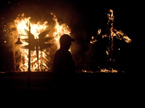 A LaSalle police officer watches the burning artwork at the Fahrenheit Festival of Fire Sculpture at the Vollmer Culture and Recreation Complex Park Amphitheatre in LaSalle Saturday, Sept. 28, 2013. (JOEL BOYCE/The Windsor Star)