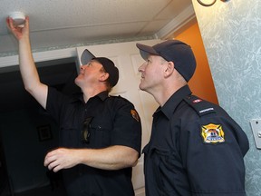 Firefighters Bob Lynch and Jerry Galasso (right) install a smoke alarm in a home in the east end of Windsor on Monday, September 30, 2013. Firefighters teamed up with Meals on Wheels and spent the day checking smoke the detectors of Meals on Wheels clients.                (TYLER BROWNBRIDGE/The Windsor Star)