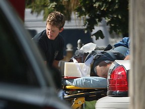 EMS paramedics remove a man on a stretcher after he was injured in a suspected home invasion on Grand Marais Rd. East, Monday, September 23, 2013.  (DAX MELMER/The Windsor Star)