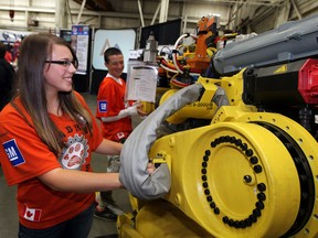 Jaeleen Koscielski of Sandwich Sabre Bytes, gets a closer look at one of Valiant's robots following the announcement that Windsor is the permanent home for the Windsor Essex FIRST Robotics Regional tournament starting in April 2014. The news conference took place at Valiant Corp., plant on Tecumseh Road East. (NICK BRANCACCIO / The Windsor Star)